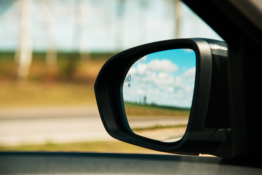 A sideview mirror on a car to represent the concept of a "blind spot"