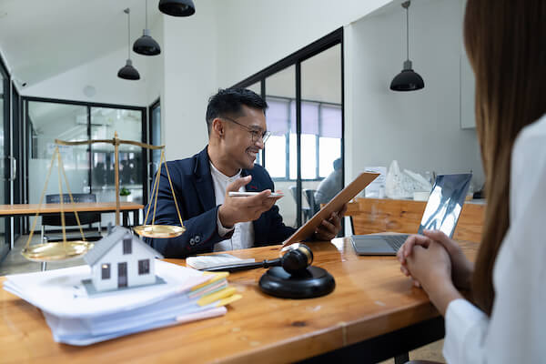 mortgage broker smiling and looking over contract with investors